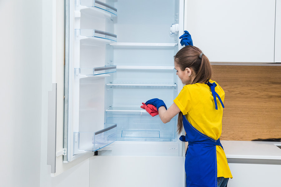 woman cleaning a fridge