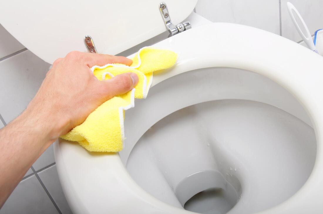 man cleaning a toilet